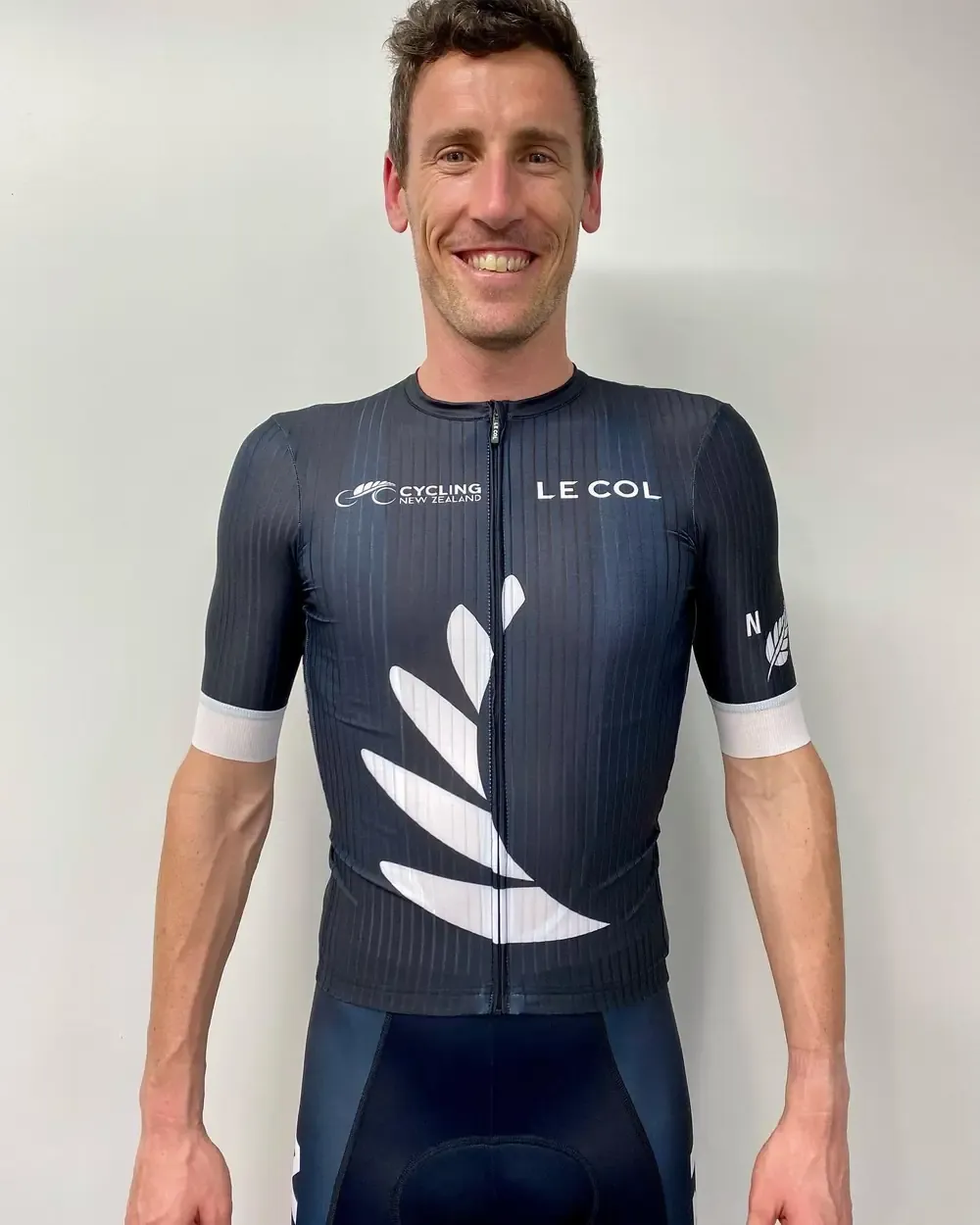 Mark Bowstead smiling in a New Zealand cycling jersey